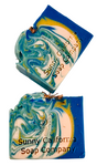 Soap swirled in blue, yellow and white with dried chamomile flowers on top. 