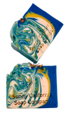 Soap swirled in blue, yellow and white with dried chamomile flowers on top. 